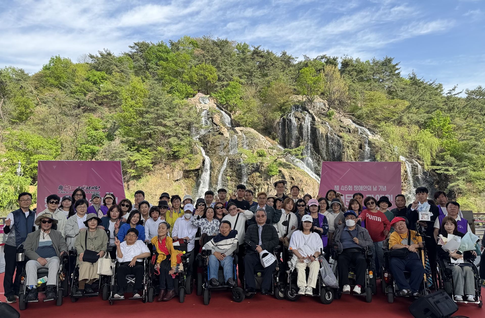 2026 서대문구 장애인 한가족 한마당(2026년 4월). 홍제폭포 앞에서 휠체어 이용 회원과 참가자들이 단체사진을 찍고 있다.